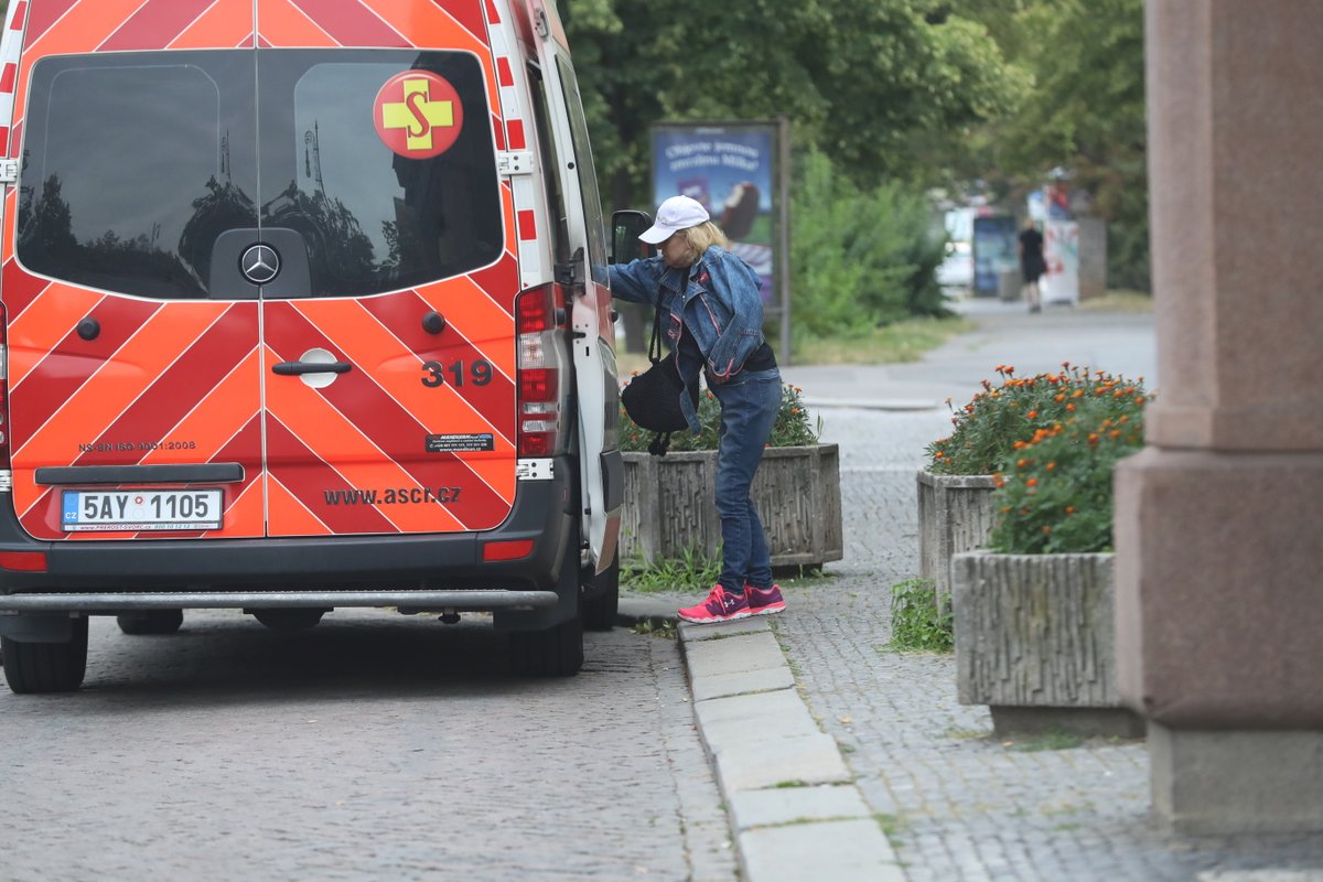 Hanka Krampolová jde se zdravotníkem do sanitky. 