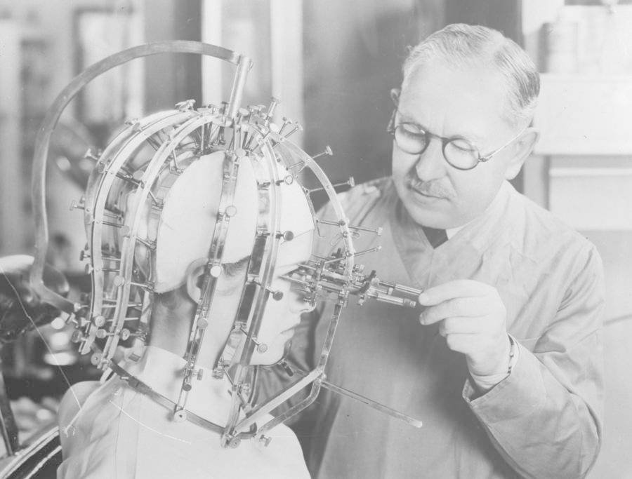 Obchodník Max Factor bere zvláštním zařízením míry obličeje, aby klientce sdělil, která místa vylepšit make-upem. USA, 1933
