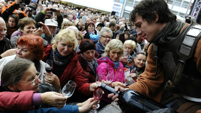 Na brněnském náměstí Svobody se 11. listopadu otevíraly první lahve Svatomartinského vína, lidé mohli ochutnat sto vzorků vín. Na snímku herec Martin Kraus (vpravo) nalévá víno návštěvníkům akce. Svatomartinské slavnosti vína se konají i v řadě dalších moravských a českých měst.