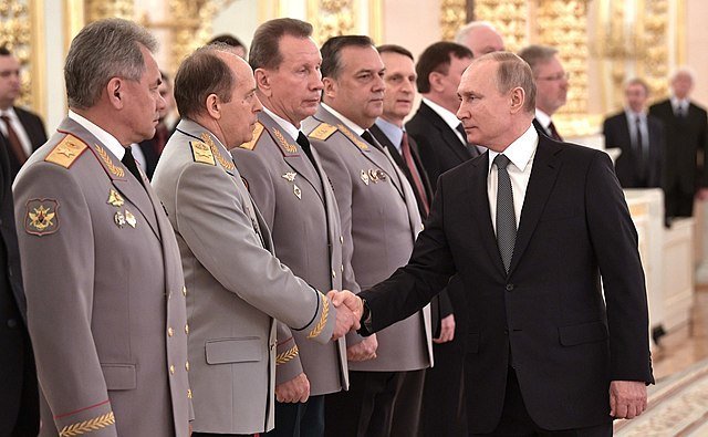 Putin s představiteli bezpečnostního aparátu. Pravici tiskne šéfovi FSB Bortnikovovi.