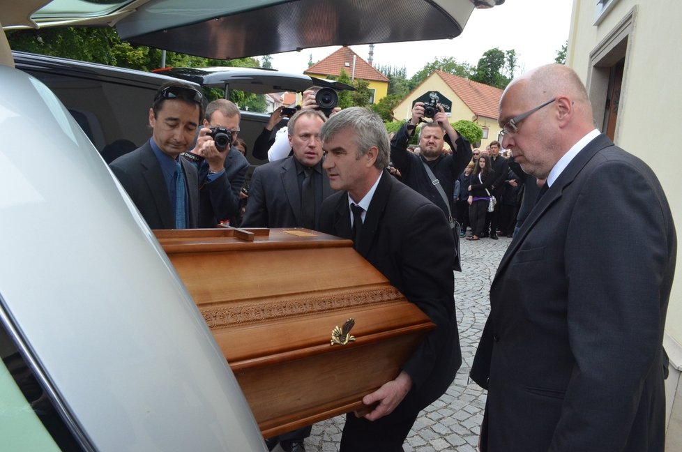 Zřízenec pohřební služby Nostalgie nakládá do stříbrného vozu rakev s ostatky zabité učitelky Veroniky H.