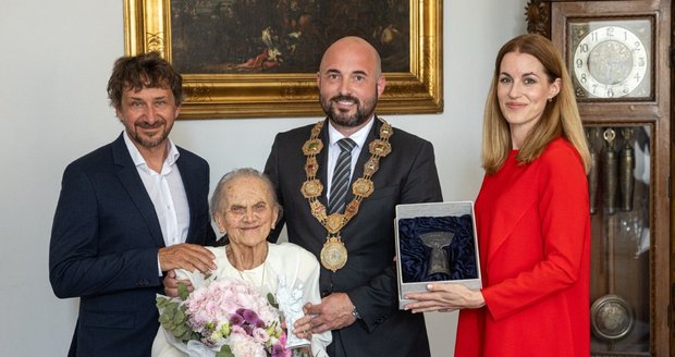 Jiřina Křížková (100) přebírá od primátora Romana Zarzyckého Cenu 1. června. Doprovází jí moderátorka a bývalá Miss Lucie Křížková, manželka jejího synovce Davida Křížka.