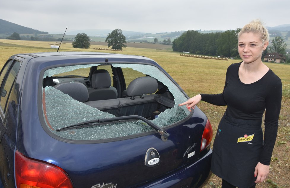 Servírka Barbora Karbanová ukazuje rozbitá skla u aut zaparkovaných před restaurací.