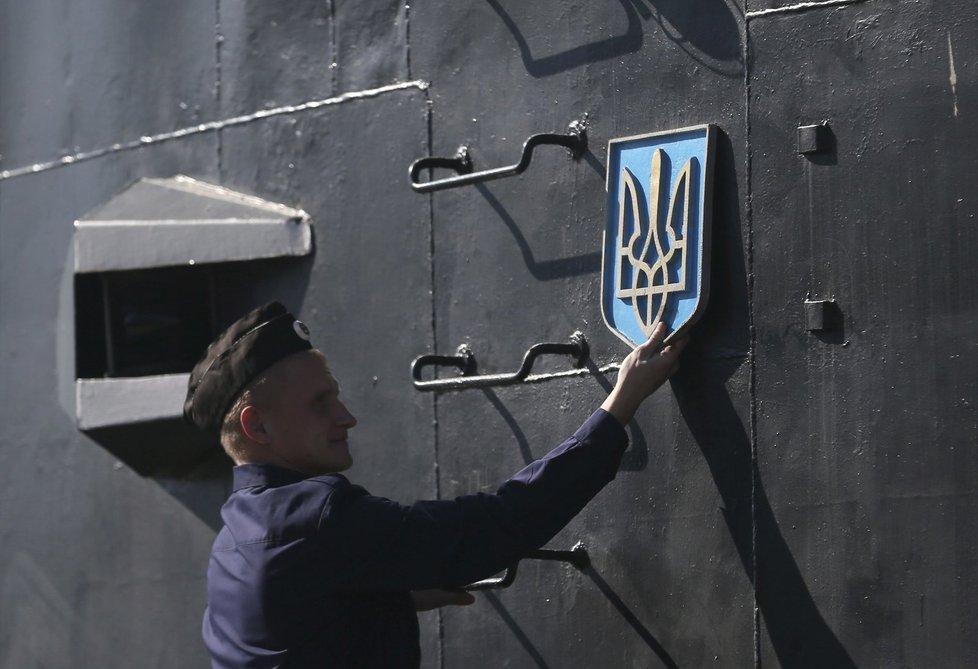 Ruský námořník odstraňuje z ponorky ukrajinský státní znak