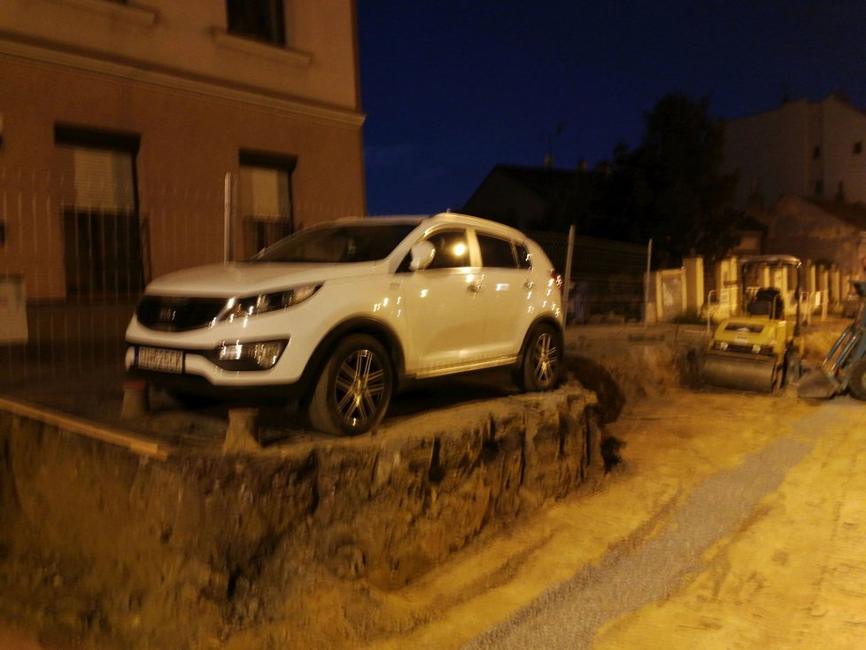 Dva dny jako na piedestalu. Kuriózní situaci ve Francouzské ulici vyřešila stavební firma po svém. Dělníci auto obkopali.