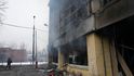 Novinář prochází kolem poškozené tělocvičny po ostřelování v Kyjevě