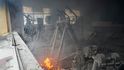 Po ostřelování v Kyjevě jsou uvnitř poškozené tělocvičny vidět kouř a plameny