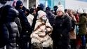 Lidé přijíždějí do dočasného ubytovacího střediska po útěku před ruskou invazí na Ukrajinu