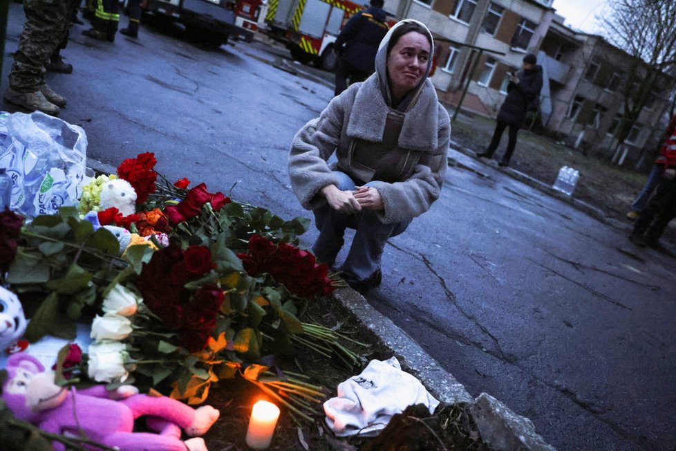Po pádu vrtulníku u Kyjeva zemřelo několik lidí. Lidé na místo tragédie nosí květiny a hračky.