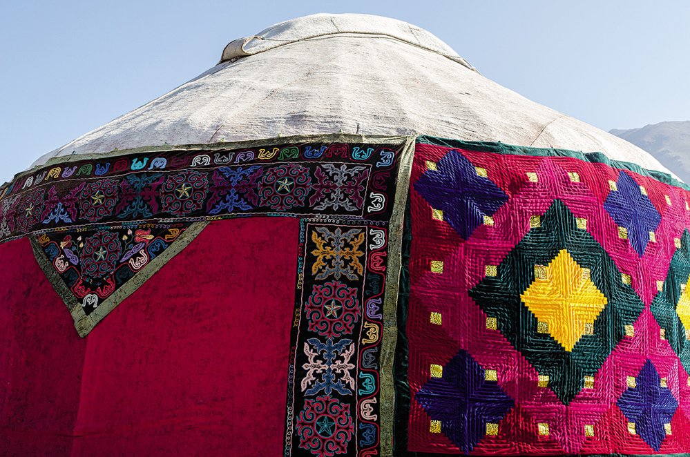 Neobvykle barevná jurta s vyšívaným šyrdakem v kempu údolí Kyrčyn