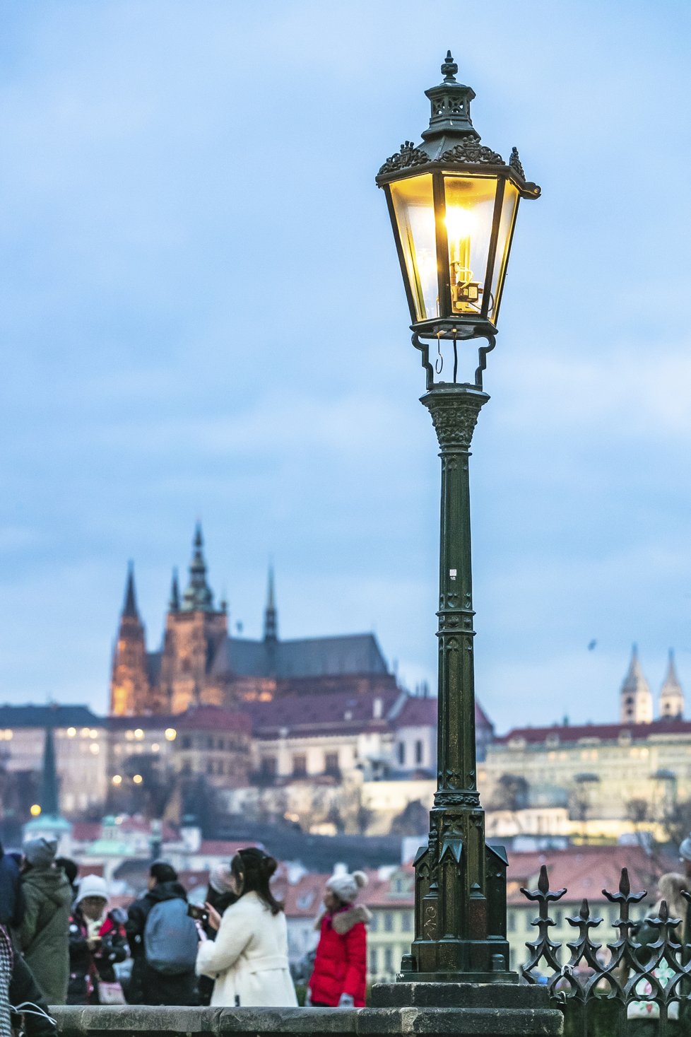 Každoroční adventní atrakce na Karlově mostě. Lampář Jan Žákovec ručně, tudíž postaru, rozsvěcuje plynové lampy.