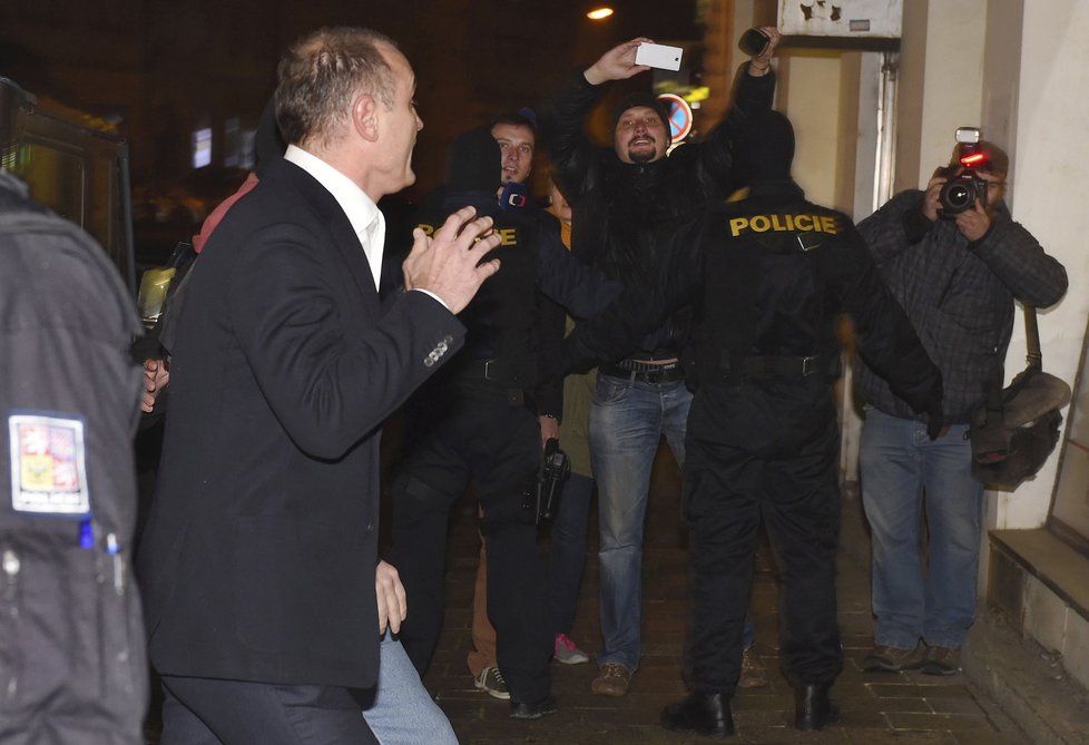 Langer nechtěl kauzu při vstupu do domu nijak komentovat. Dům v té chvíli střežilo šest policistů v kuklách.