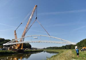 Speciální jeřáb usadil mostní konstrukci přes hraniční řeku Moravu v Mikulčicích na Hodonínsku. Lávka bude součástí stezky pro pěší a cyklisty, která propojí Mikulčice se slovenskými Kopčany.