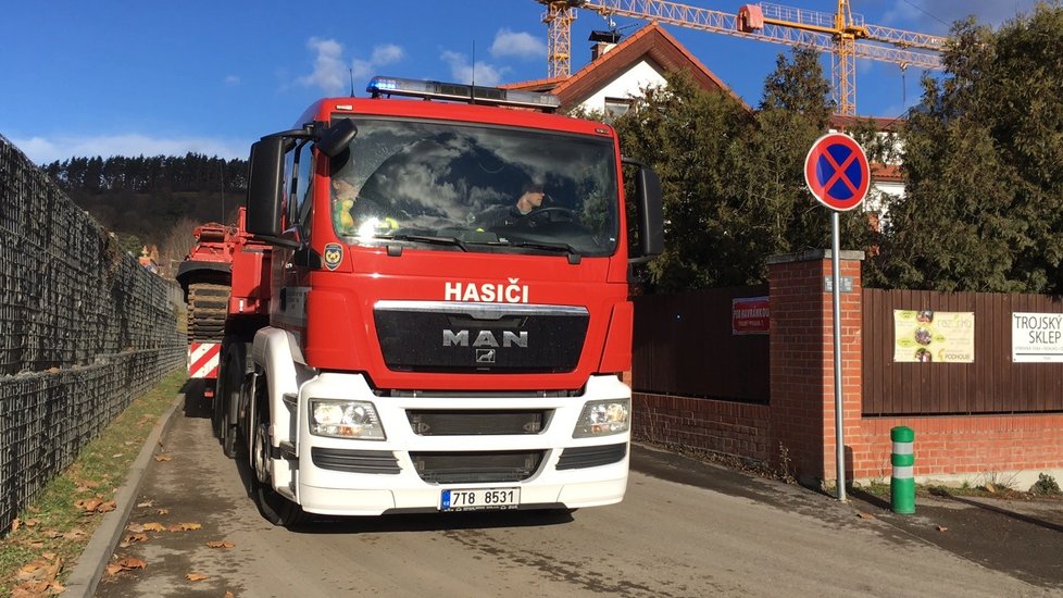 Hasiči do Troji přijeli s těžkou technikou, budou z Vltavy tahat trosky lávky.