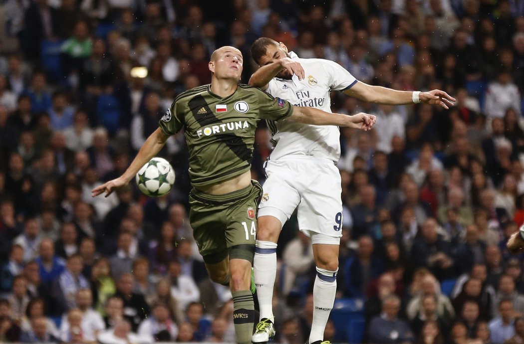 Obránce Legie Varšava Adam Hloušek v hlavičkovém souboji s útočníkem Realu Madrid Karimem Benzemou