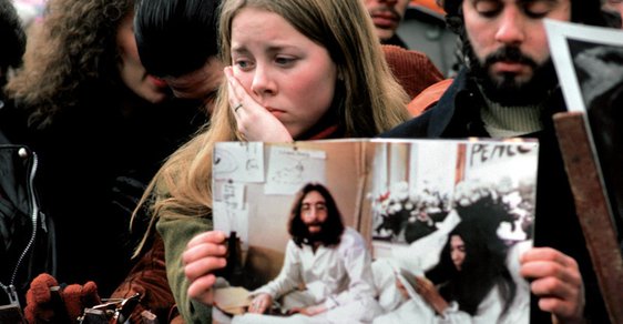 Prosinec 1980. Ve spontánní reakci na Lennonovo zavraždění se v newyorském Central Parku sešly tisíce lidí. Mladý pár drží fotografii Johna Lennona a Yoko Ono během jejich mírového protestu „bed -in“ v Amsterdamu.