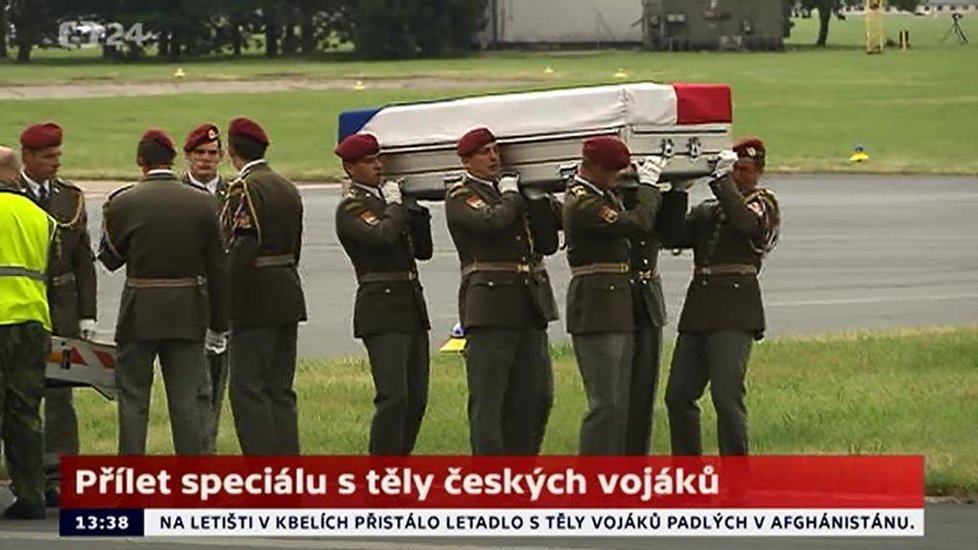 Vojáci vynášejí rakev s prvním tělem padlého vojáka