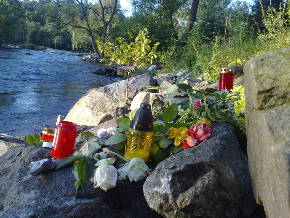 Lidé se zastavují v místě tragédie položit zde květiny a svíčky.