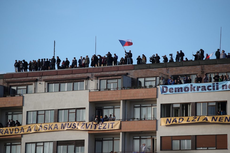 Lidé na střeše bytového domu Molochov během letenské demonstrace spojené s 30. výročím sametové revoluce (16. 11. 2019)