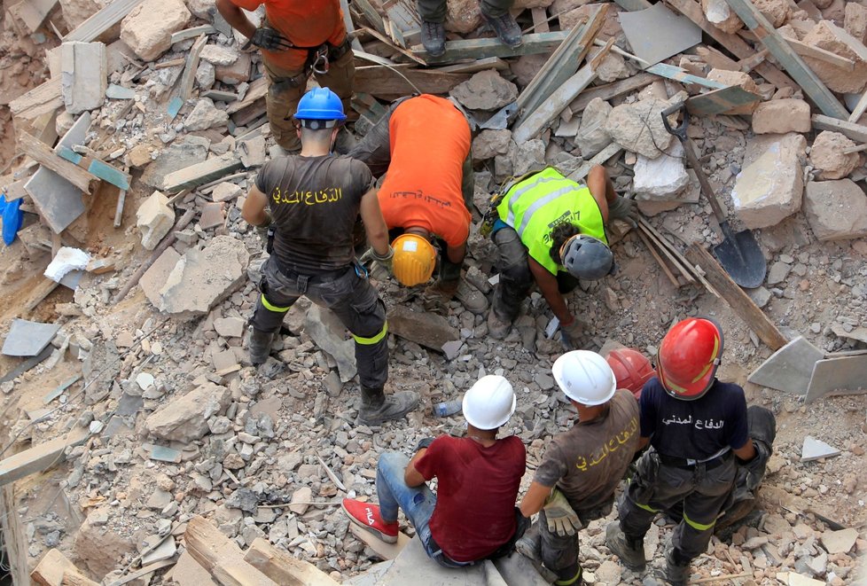 Záchranáři prohledávají trosky v Bejrútu.