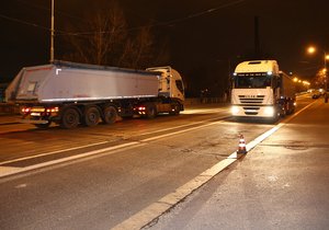 Dvě nákladní auta se míjejí na Libeňském mostě.