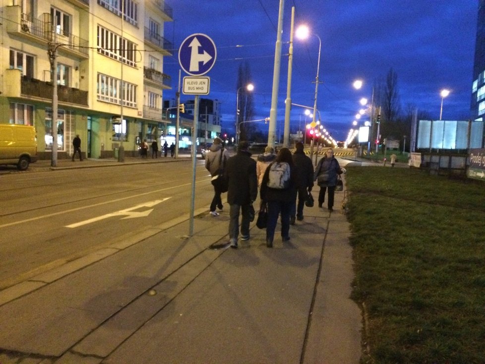 Lidé po Libeňském mostu chodí pěšky, aby se dostali na druhou stranu. Pro autobusy i tramvaje je uzavřen.