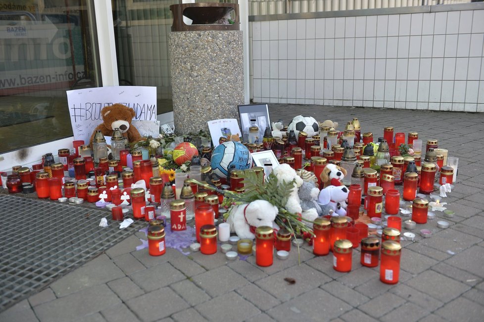 Adamovi kamarádi kolem dveří rozestavěli svíčky a fotografie na jeho památku.