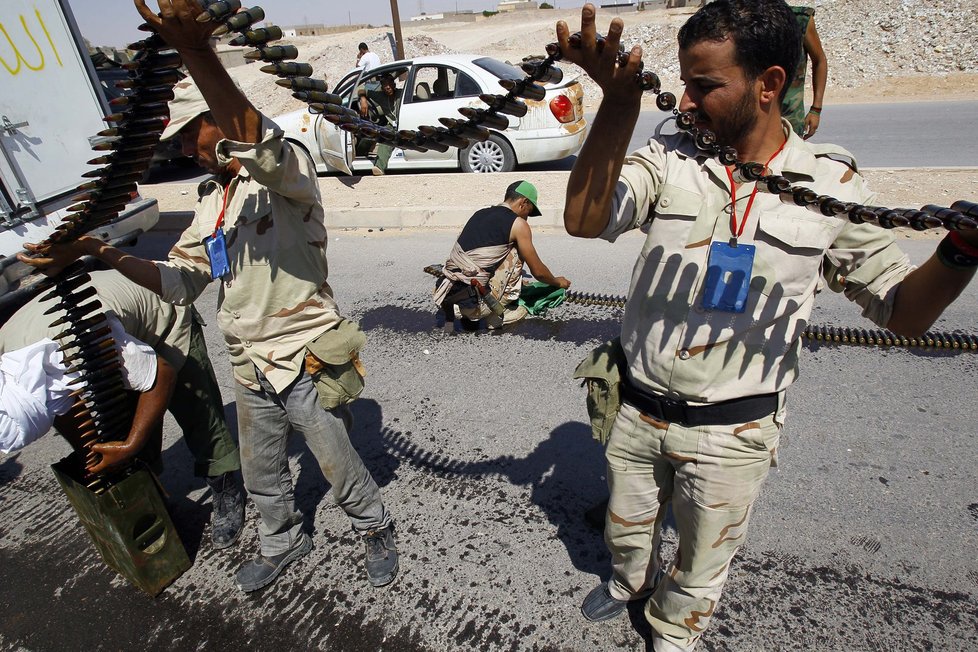 Libyjští bojovníci připravují pás munice.