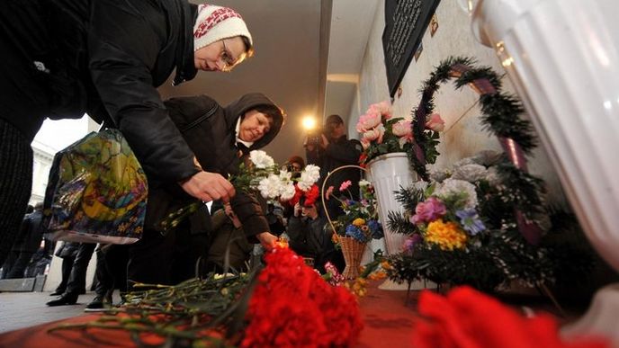 Lidé pokládají květiny a rozsvěcují svíčky u pamětní desky obětí atentátu v minském metru.