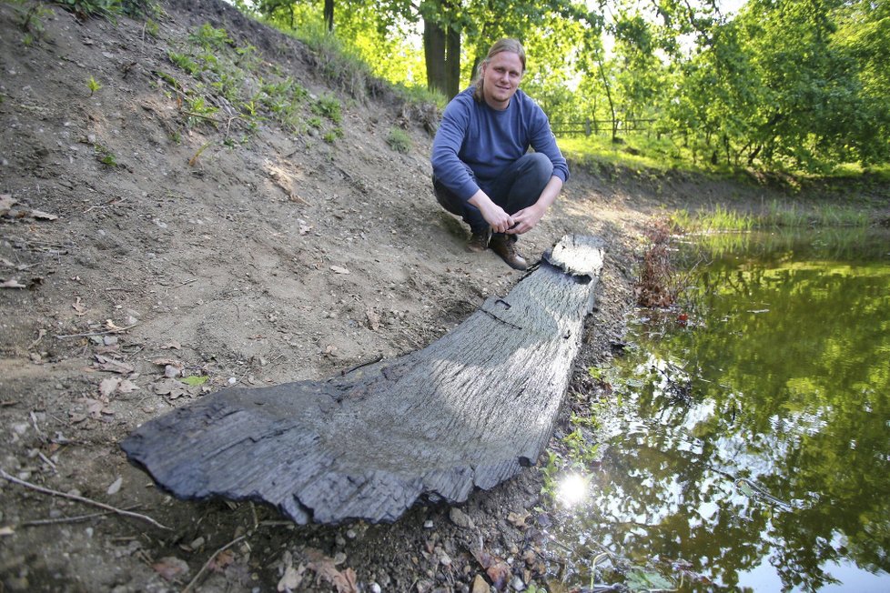 Archeolog Libor Kalčík u nalezeného kusu zbytku lodi, která vznikla minimálně před tisíci lety.