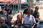 Kapitánka lodi s migranty Carola Rocketa v doprovodu finanční policie v sicilském přístavu Porto Empedocle