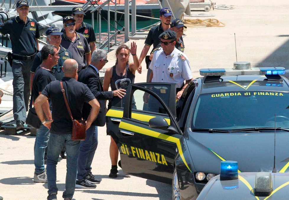 Kapitánka lodi s migranty Carola Rocketa v doprovodu finanční policie v sicilském přístavu Porto Empedocle