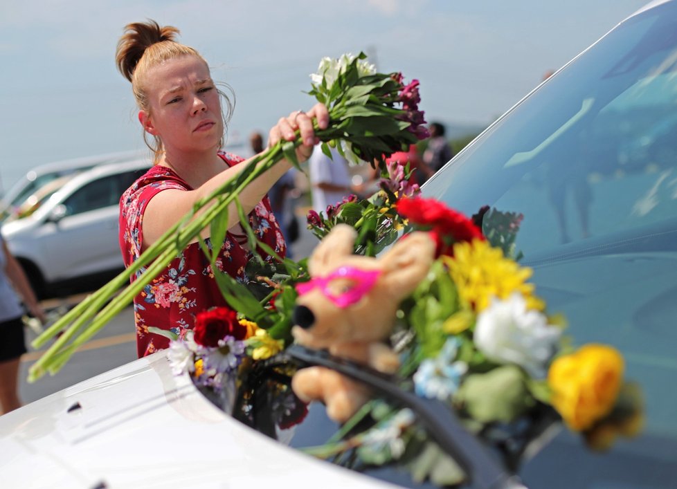Jasmine Burkhardt pokládá květiny u auta, které patřilo jedné z obětí lodního neštěstí v Missouri.
