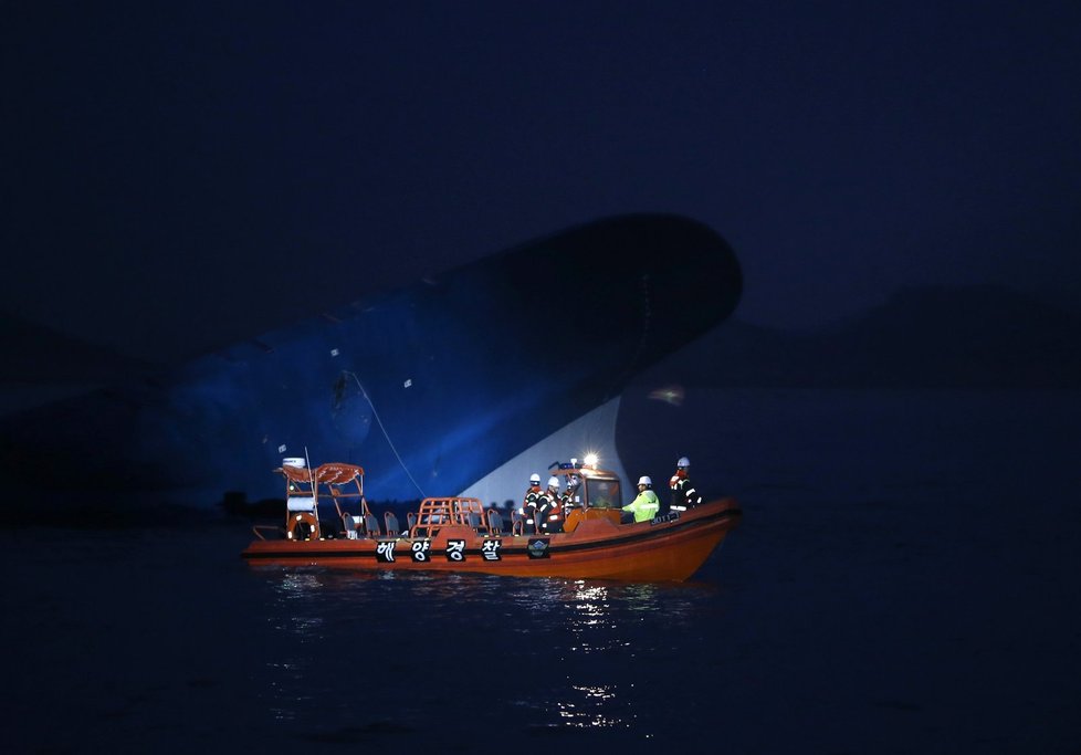 Záchranáři při nočním prohledávání v okolí potopeného trajektu.