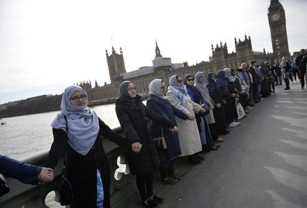Reakce muslimek na útok: V modrých šátcích se na znamení solidarity s oběťmi chytily na mostě za ruce.