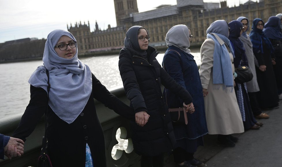 Muslimky v modrých šátcích se na znamení solidarity s oběťmi chytily na mostě za ruce.