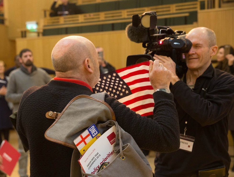 Jeden z Russellových pomocníků začal před Khanem i kamerami mávat americkou vlajkou, tu ale celou dobu držel obráceně.