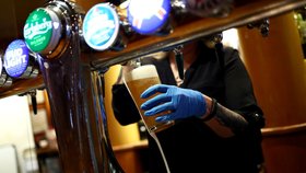 Barmanka točí pivo v jedné z londýnských hospod (4. 7. 2020)