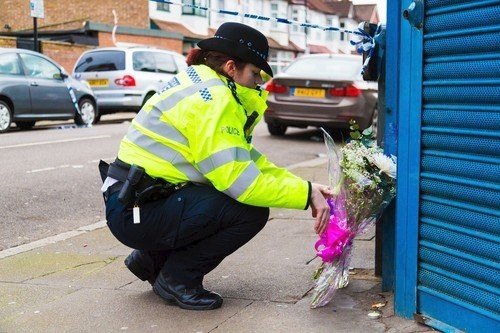 Londýnští policisté u květin, položených na památku zavražděné Taneshy Melbourneové