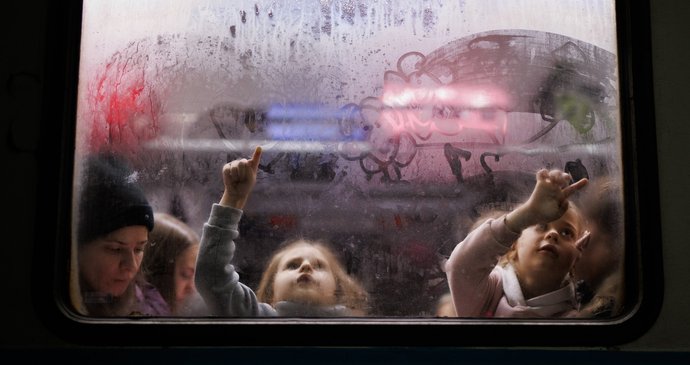 Holčičky kreslí na okno jednoho z vagonů srdíčka a kytičky tatínkům, kteří stojí na peroně nádraží ve Lvově.