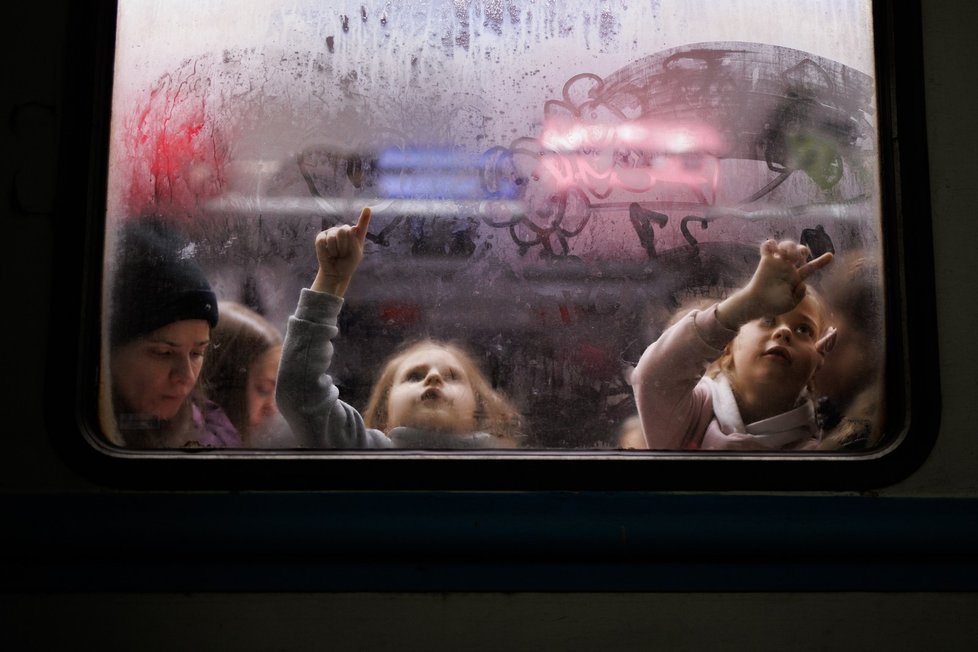 Holčičky kreslí na okno jednoho z vagonů srdíčka a kytičky tatínkům, kteří stojí na peroně nádraží ve Lvově.