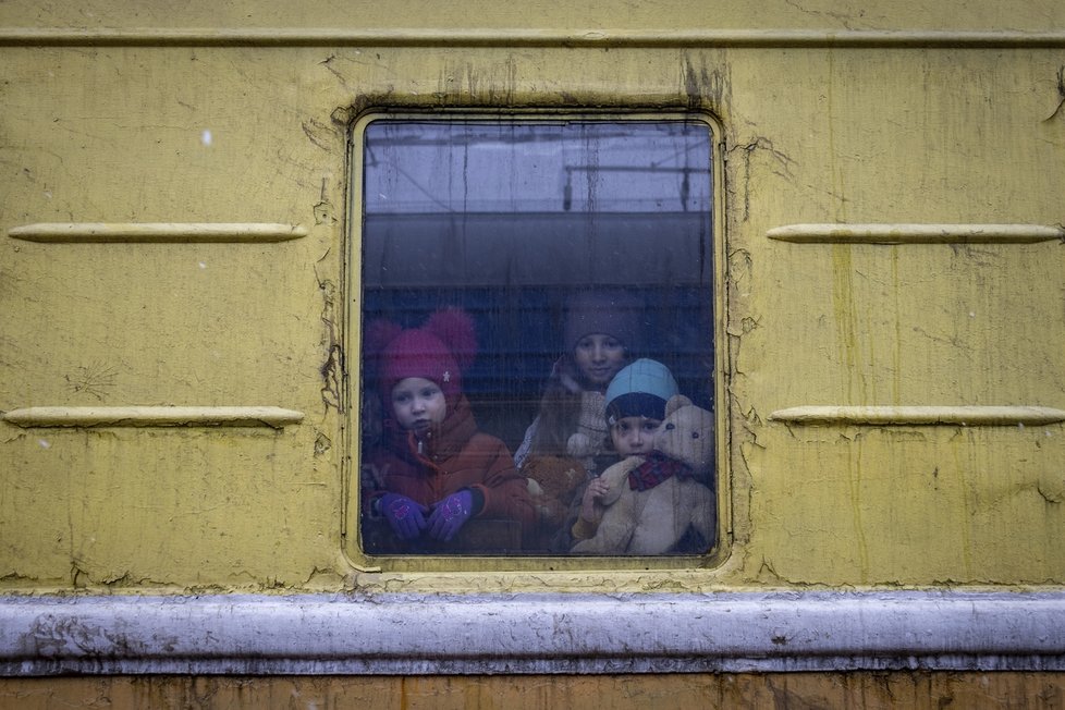 Děti Vlada (vlevo), Katrin a Danilo se dívají z okna nevytopeného vagonu evakuačního vlaku, který je veze z Charkova do Lvova.