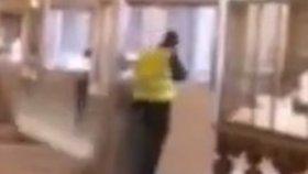 Jeden ze zlodějů v reflexní vestě zachycený zřejmě při vloupání do vitríny v Louvru.