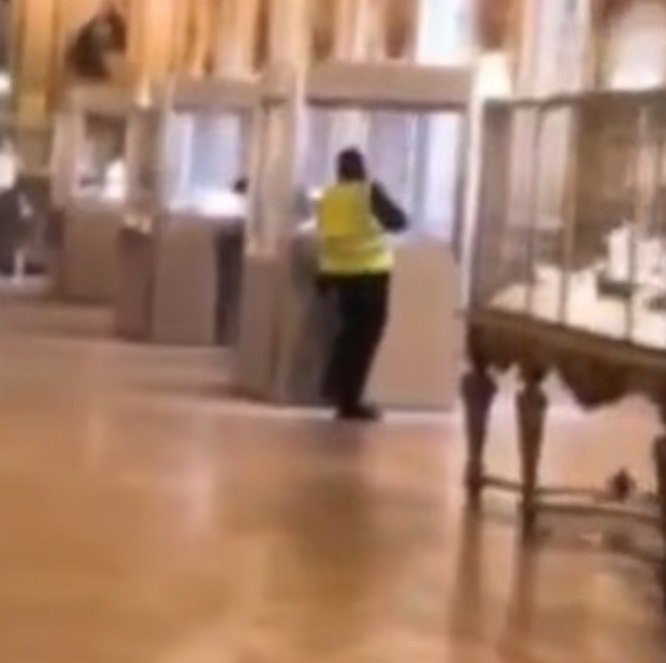 Jeden ze zlodějů v reflexní vestě zachycený zřejmě při vloupání do vitríny v Louvru Jeden ze zlodějů v reflexní vestě zachycený zřejmě při vloupání do vitríny v Louvru