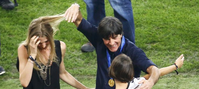 Joachim Löw dovádí při oslavách na hřišti s partnerkami svých svěřenců Schweinsteigera a Neuera.