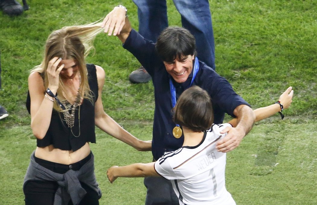 Joachim Löw dovádí při oslavách na hřišti s partnerkami svých svěřenců Schweinsteigera a Neuera.