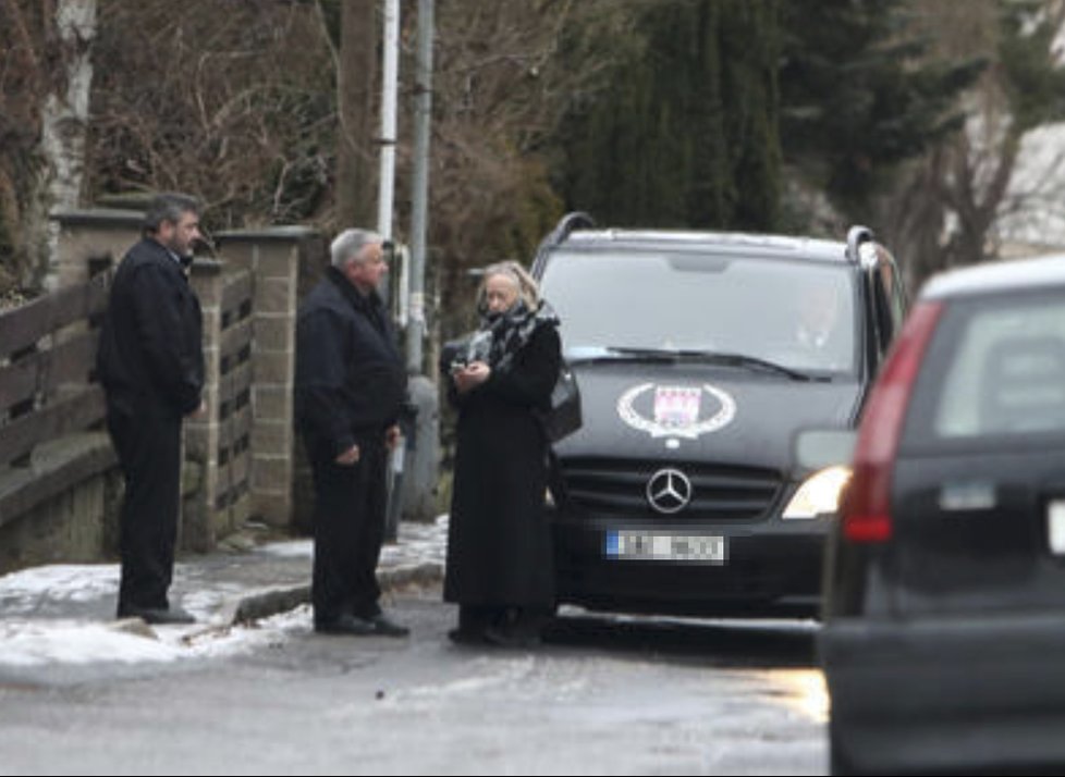 Před vilu přijelo pohřební auto.