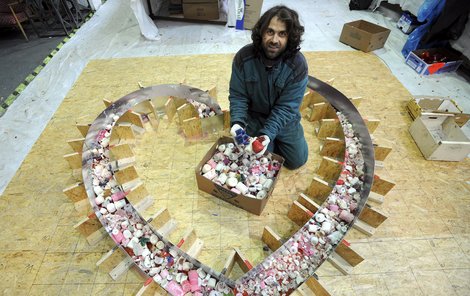 Lukáš Gavlovský skládá svíčky do tvaru srdce. Srdce se tvoří po částech, jako cihly se pak složí až u Národního divadla.