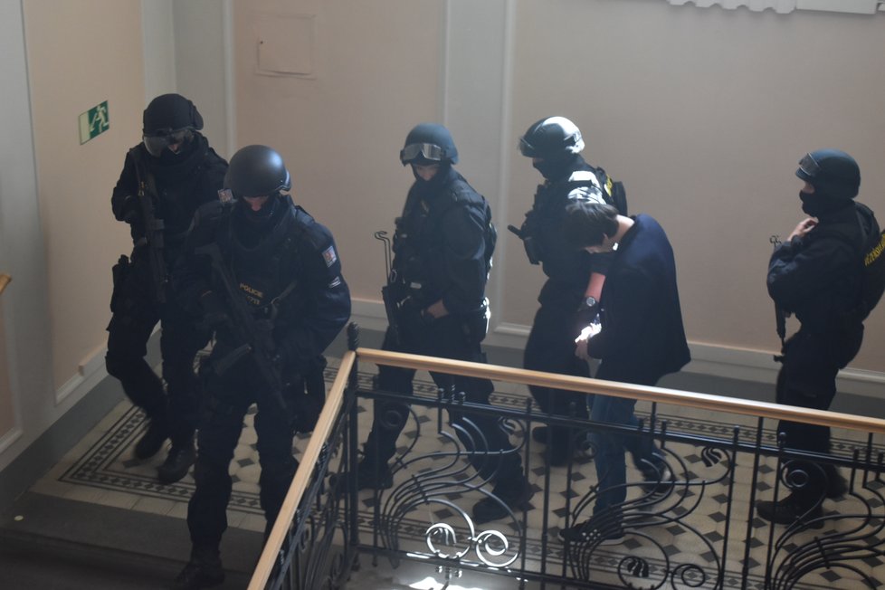 Eskortu Lukáši H. dělala početná skupina maskovaných policistů v neprůstřelných vestách. Další policisté seděli v soudní síni v civilu.