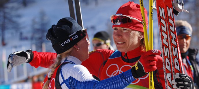 Kateřina Neumannová se v cíli olympijského závodu v Turíně objímá Kristinu Šmigunovou-Vähiovou
